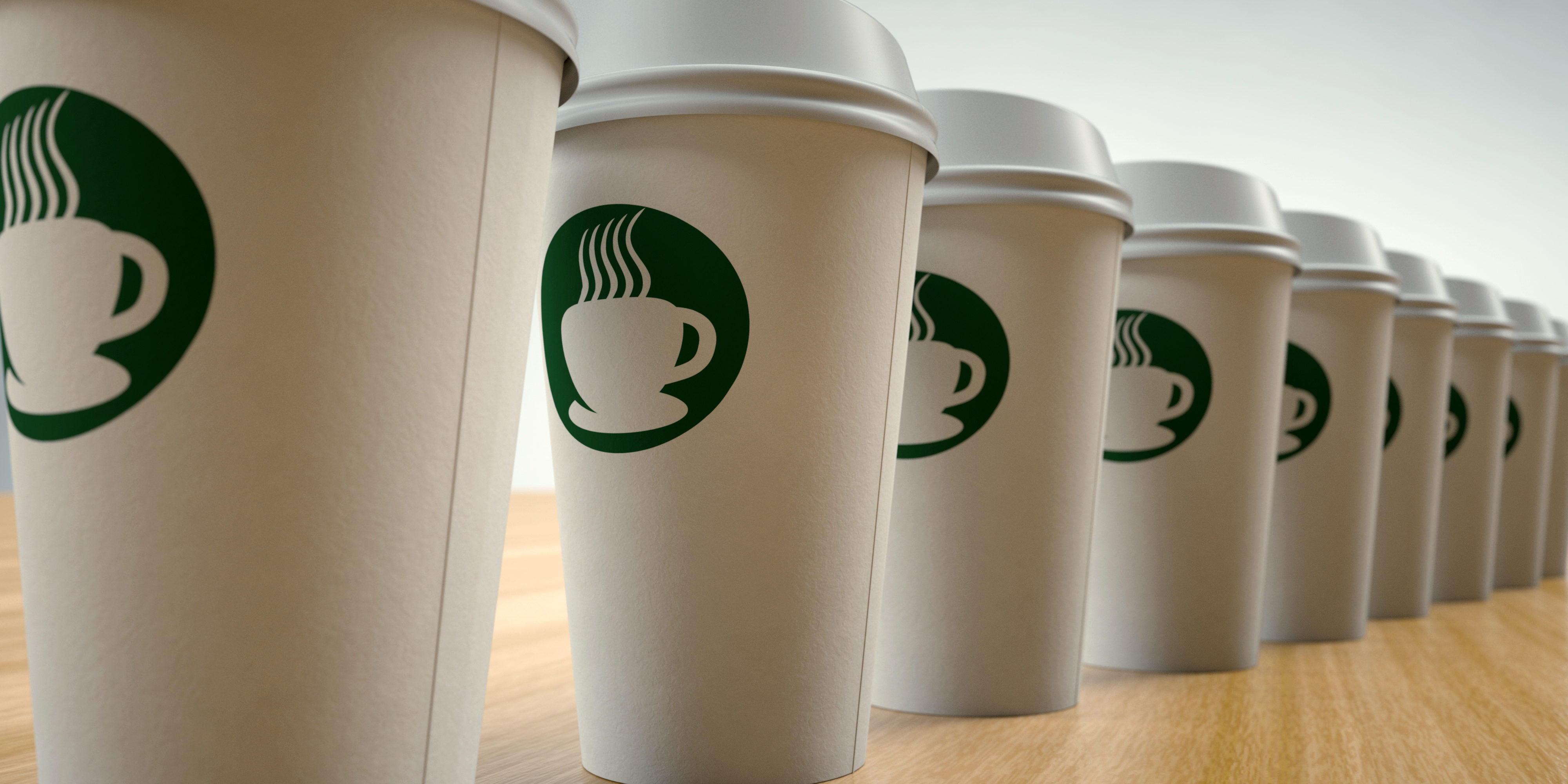 Paper Coffee Cups On Arranged In A Row With A Green Starbucks-like Logo